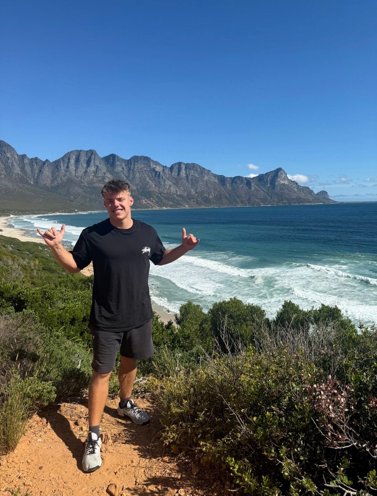 Man posing on coastal mountain beach