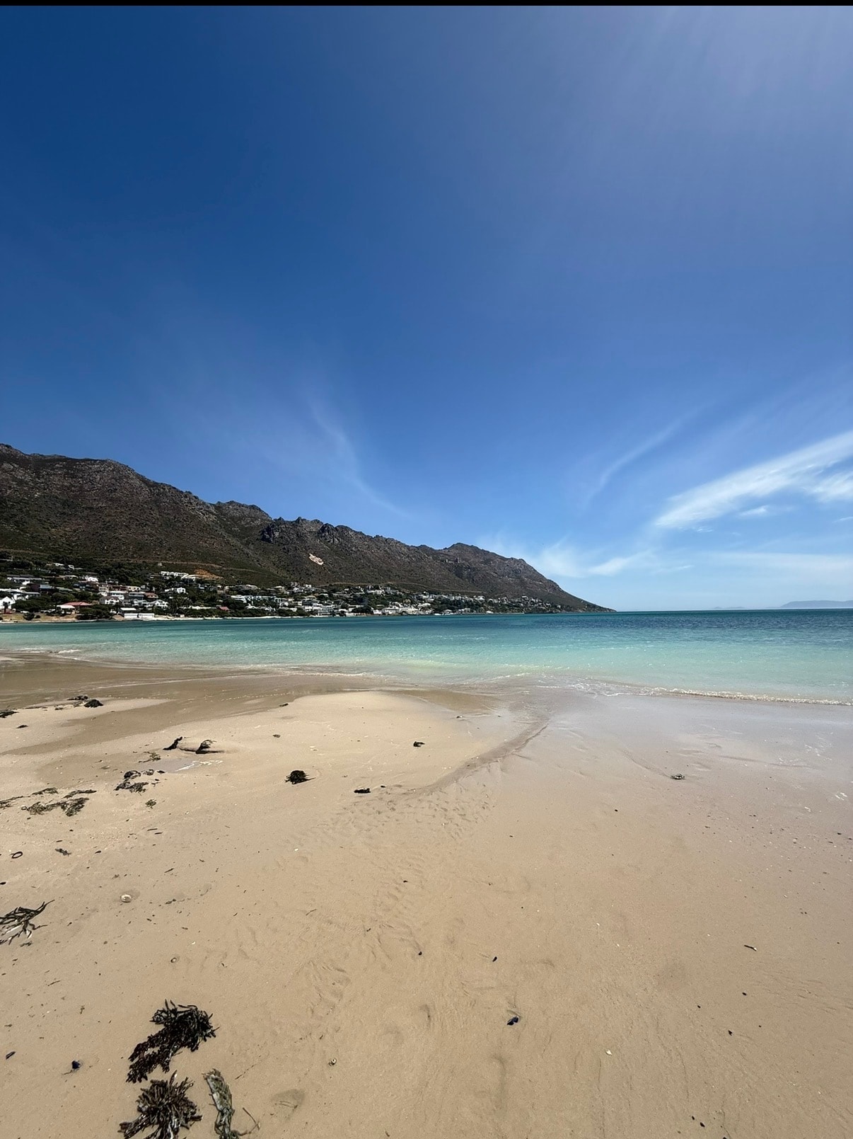 Sandy beach with turquoise water and mountains