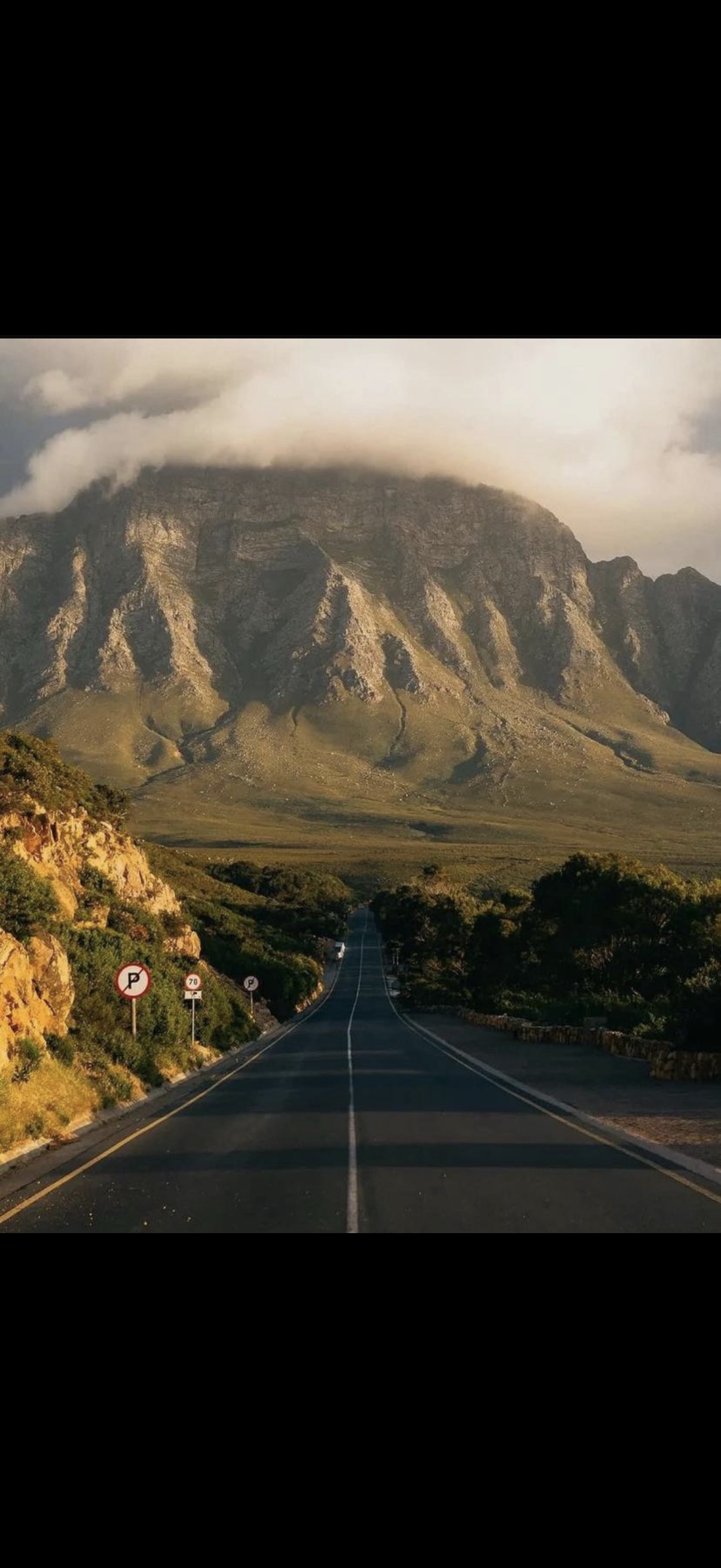 Straight road toward dramatic mountain peak